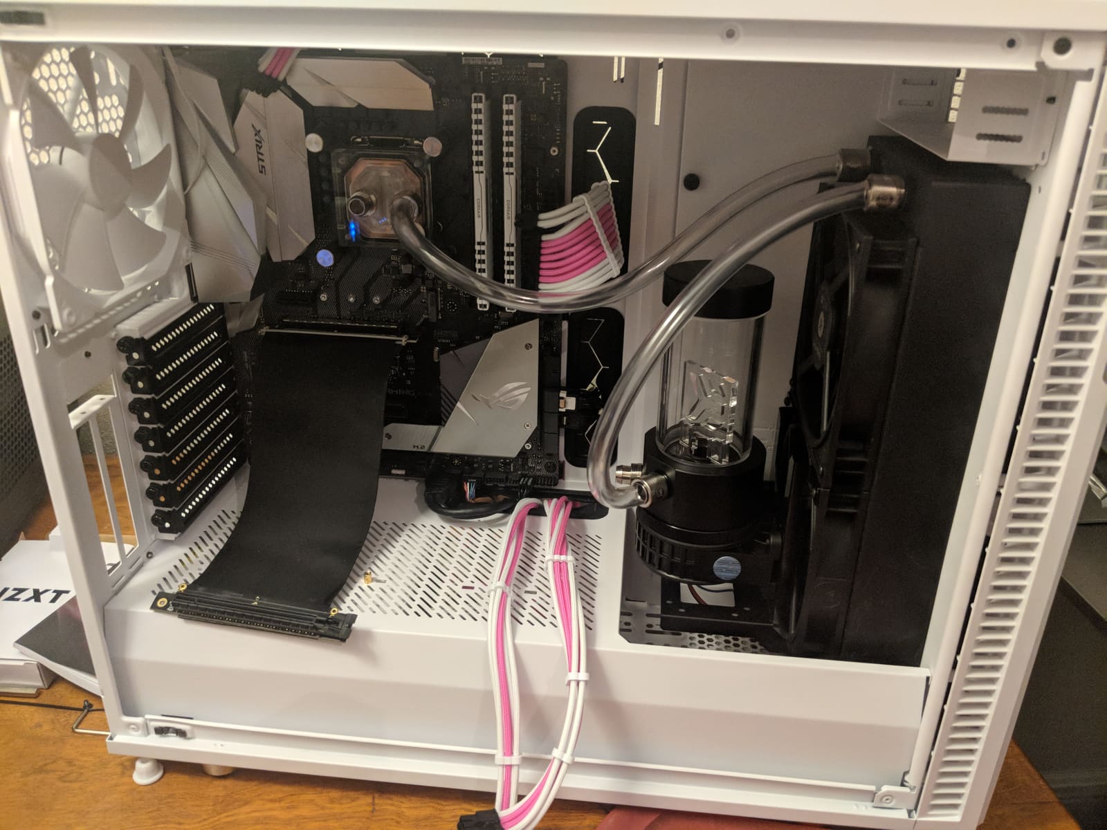 The first runs of clear tubing between the CPU block, radiator, and reservoir, with the GPU not yet mounted
