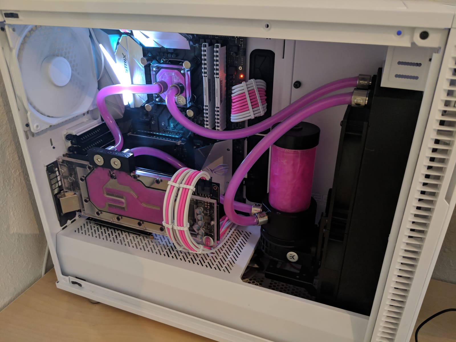 The finished build lit up, with pink coolant running through clear tubing